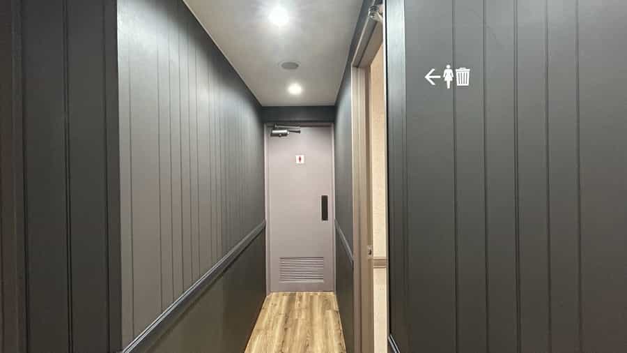 【女子トイレは共用扉の右手にございます】